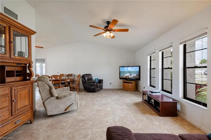 Living area with ceiling fan and light tile patterned flooring