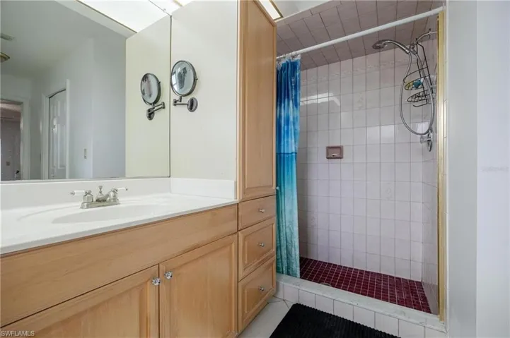 Bathroom featuring a stall shower, vanity, and light tile patterned floors