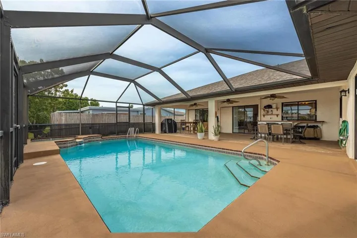 Combined pool / hot tub featuring outdoor dining area, a patio, a lanai, and a sunroom