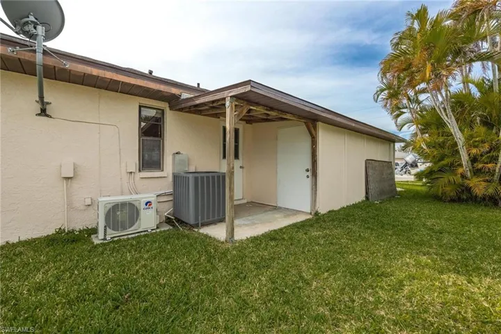 Rear view of property with a yard, a patio area, and stucco siding