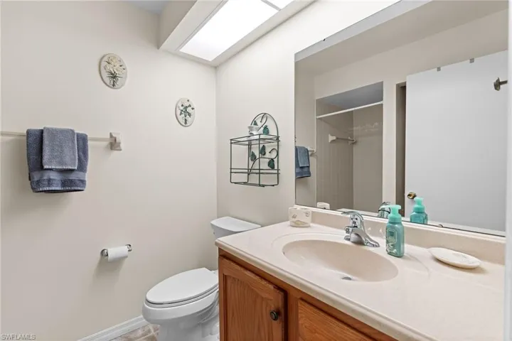 Guest Bathroom featuring vanity, toilet, a skylight, and a tile shower