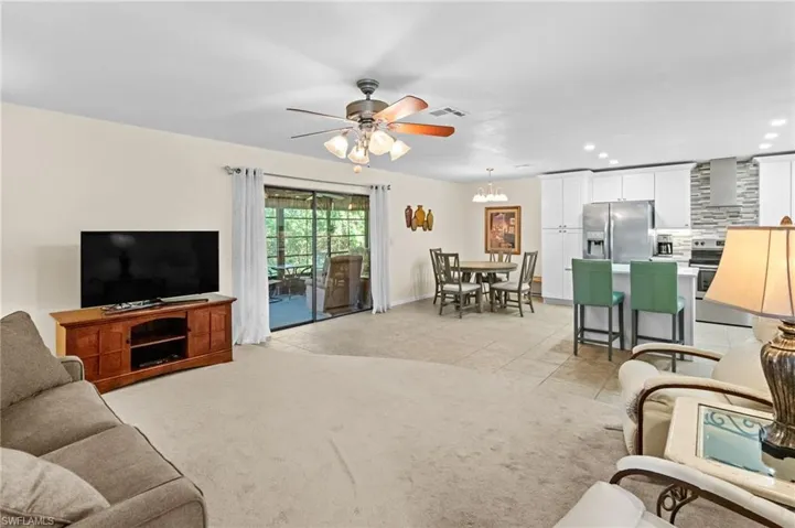 Carpeted living room featuring ceiling fan