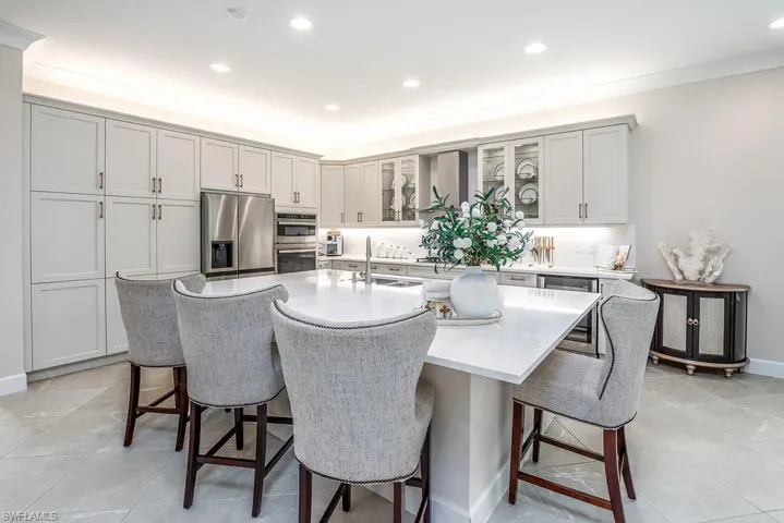 Kitchen featuring stainless steel appliances, a center island with sink, sink, and a kitchen bar