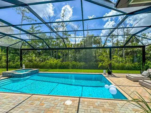 View of pool with a patio, a lanai, and an in ground hot tub