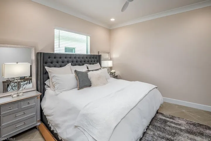 Bedroom featuring crown molding, ceiling fan, and light tile floors