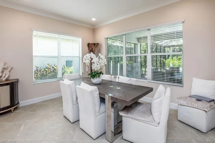 Dining area with crown molding and light tile floors