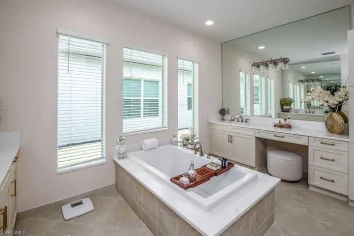 Bathroom with tile floors, tiled bath, and vanity with extensive cabinet space