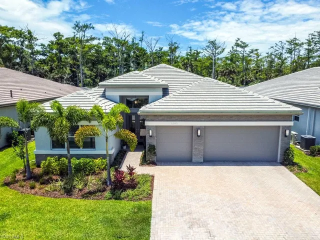 View of front of home featuring a front yard, a garage, and central air condition unit