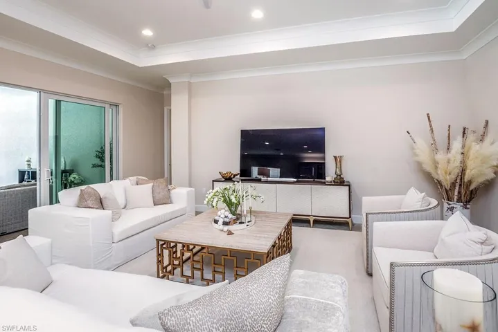 Living room featuring a tray ceiling and crown molding