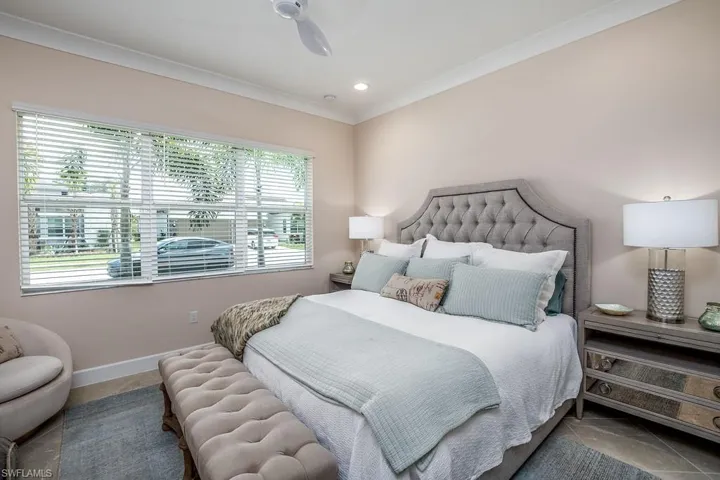 Tiled bedroom featuring ornamental molding and ceiling fan