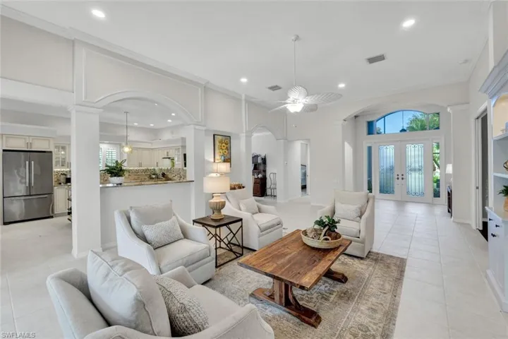 Living area with french doors, arched walkways, light tile patterned floors, a ceiling fan, and recessed lighting