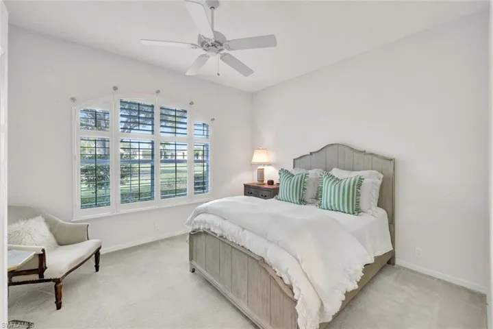Carpeted bedroom featuring a ceiling fan and baseboards