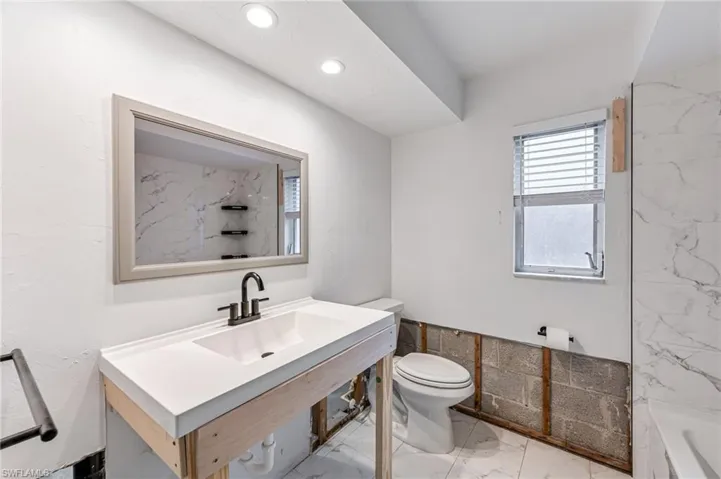 Bathroom with a bath, toilet, and sink