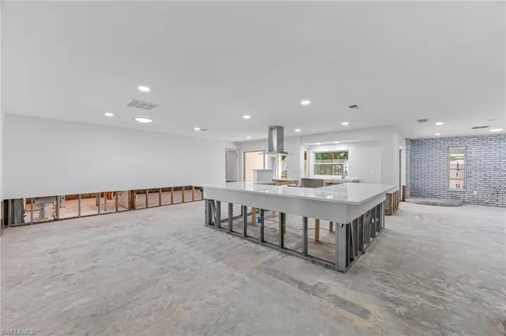 Kitchen with a center island, a breakfast bar, and island range hood