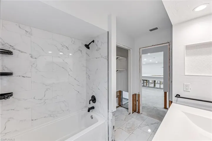 Bathroom with vanity and tiled shower / bath