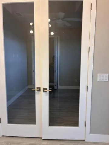 Detailed view of ceiling fan, french doors, wood finished floors, and recessed lighting