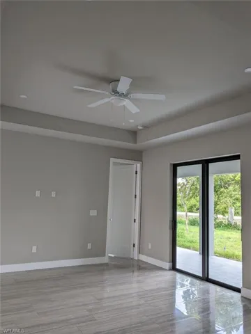 Unfurnished room with ceiling fan, light wood-style floors, a tray ceiling, and recessed lighting