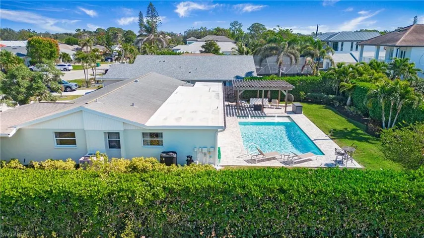 Outdoor pool with a pergola, a patio area, a residential view, and a lawn