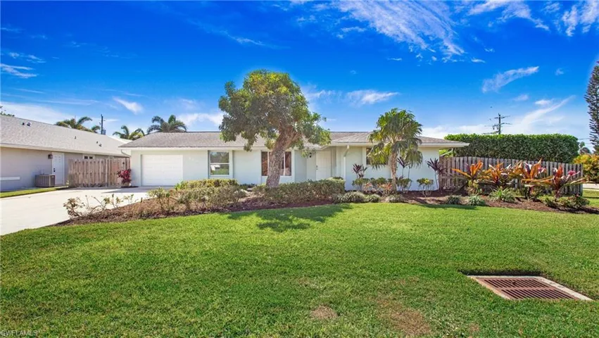 Ranch-style house with driveway, an attached garage, and stucco siding