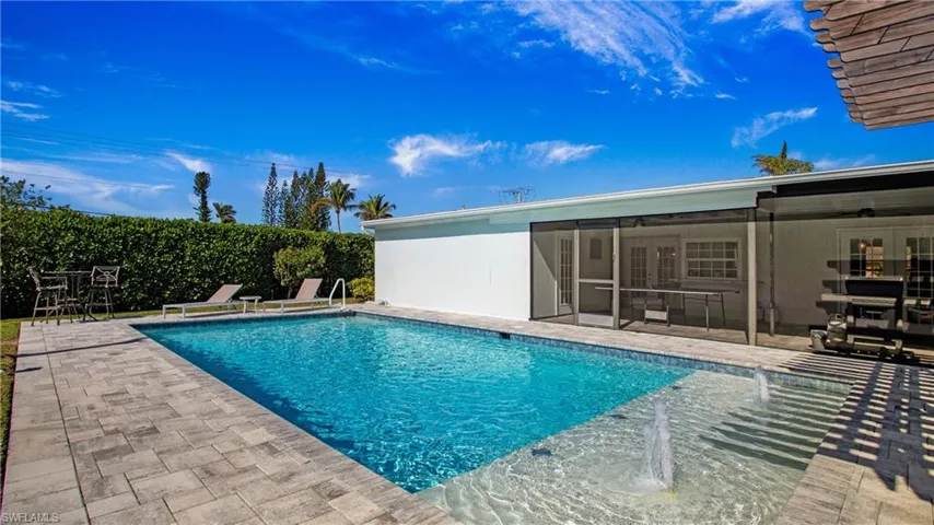 View of pool with patio surround and a sunroom