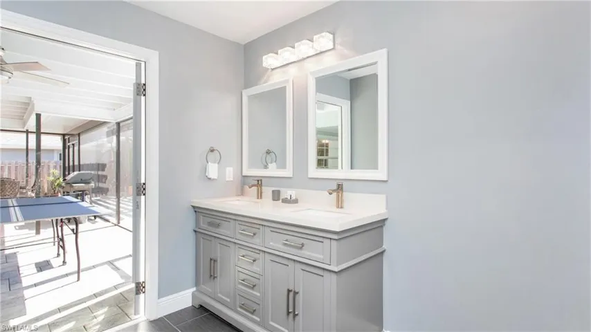 Full bathroom featuring double vanity and baseboards