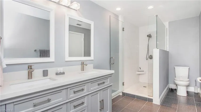 Bathroom with double vanity, a stall shower, and recessed lighting