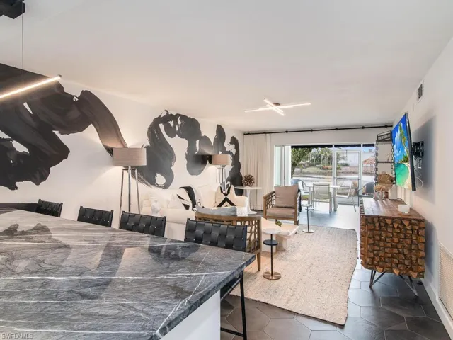 Living area with dark tile patterned flooring and visible vents