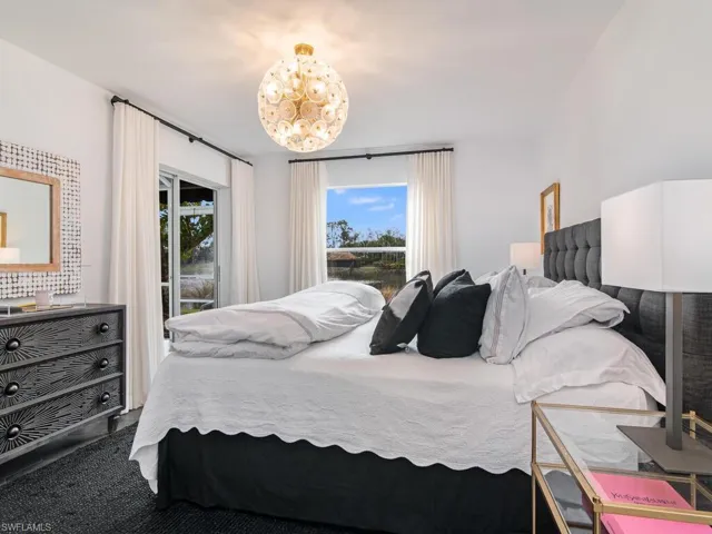 Bedroom featuring a notable chandelier and access to outside
