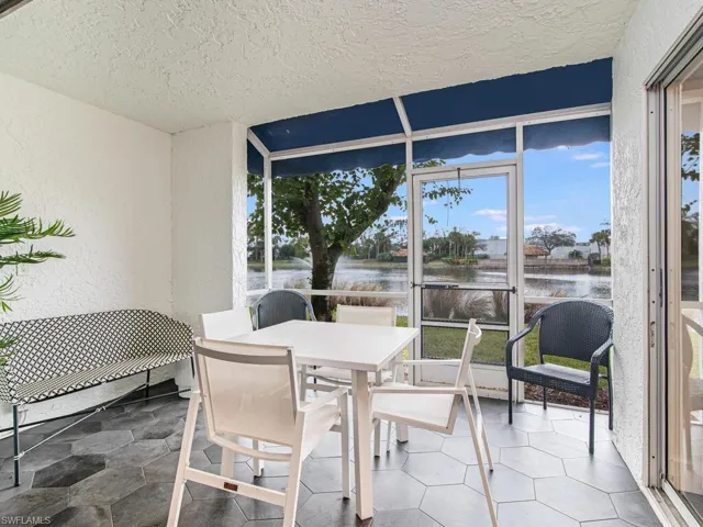 Sunroom featuring a water view and outdoor dining area