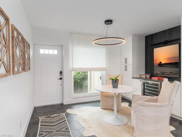 Foyer entrance with plenty of natural light, baseboards, and wine cooler