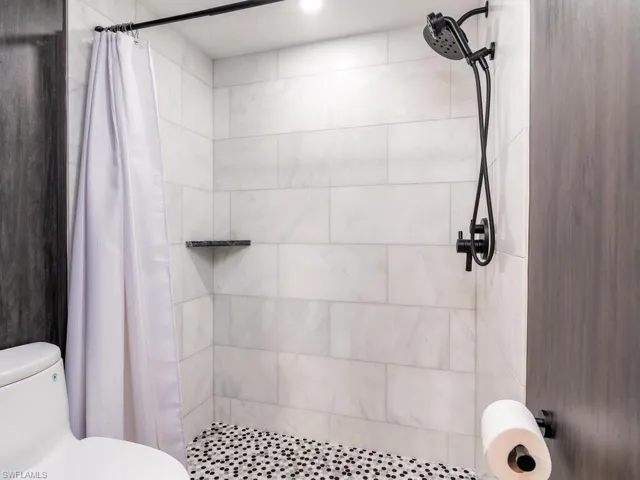 Full bathroom with a stall shower and toilet