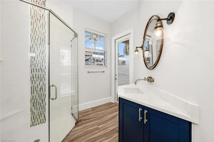 Bathroom featuring vanity, a shower with shower door, and hardwood / wood-style floors