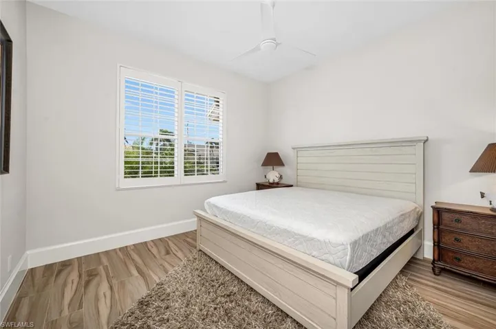 Bedroom with light hardwood / wood-style floors and ceiling fan