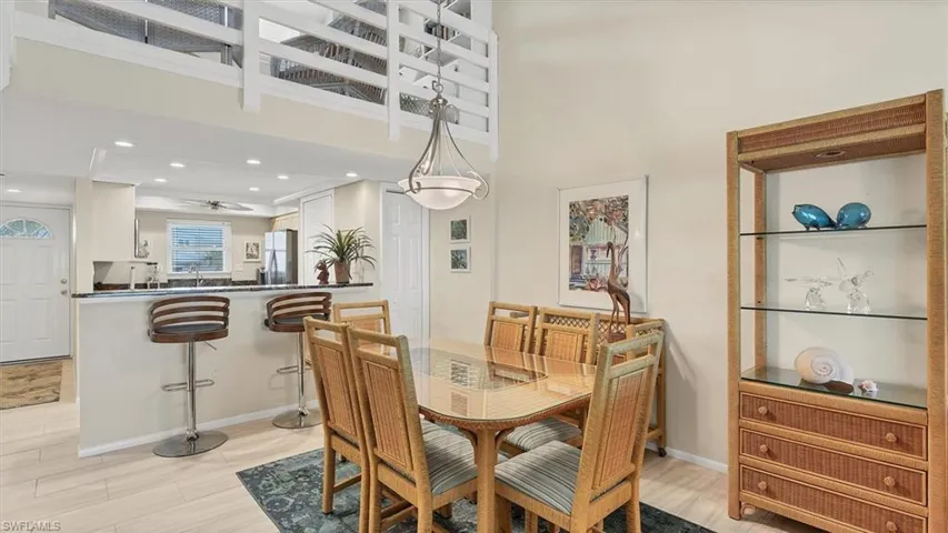Dining area featuring recessed lighting, light wood finished floors, ceiling fan, and a towering ceiling