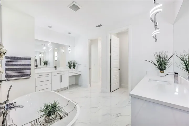 Bathroom featuring tile patterned floors, a tub, and vanity