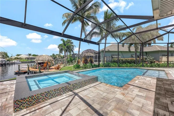 View of pool with a lanai, an in ground hot tub, and a patio