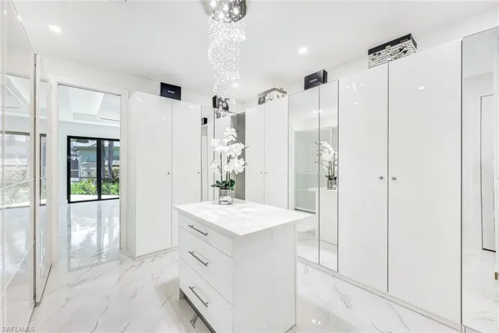 Bathroom featuring a shower with door, a notable chandelier, tile patterned flooring, and vanity
