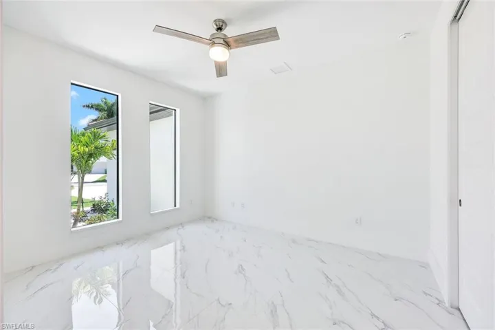 Empty room with ceiling fan and tile patterned flooring