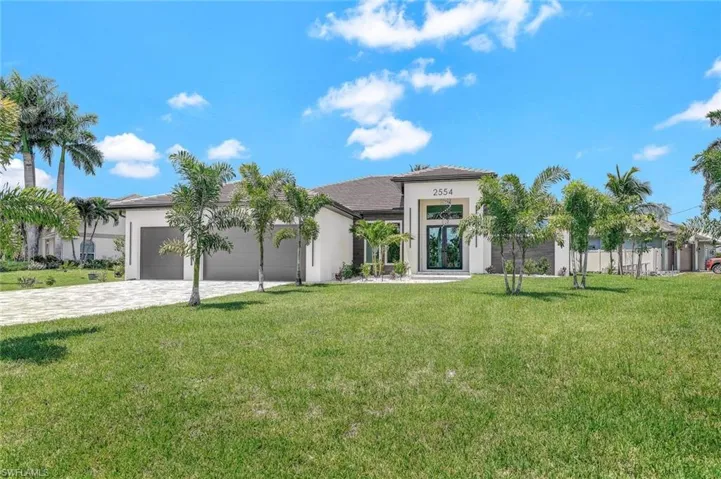 Mediterranean / spanish-style house with a garage and a front yard