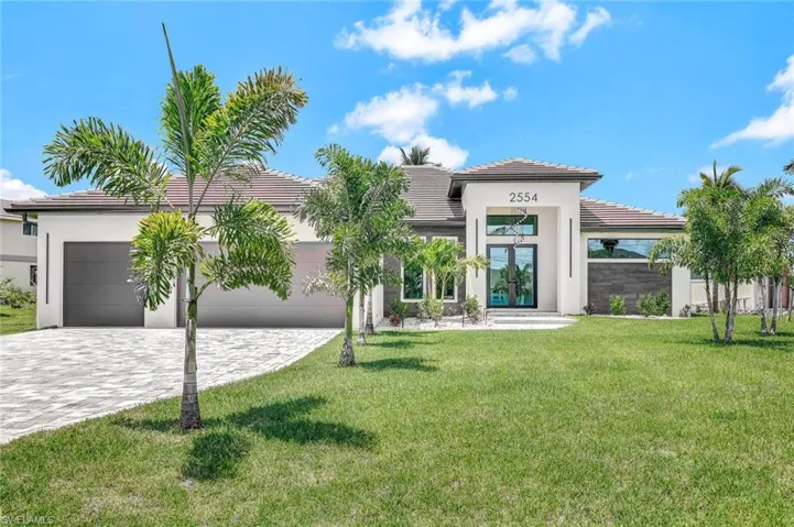 View of front of house with a garage and a front lawn
