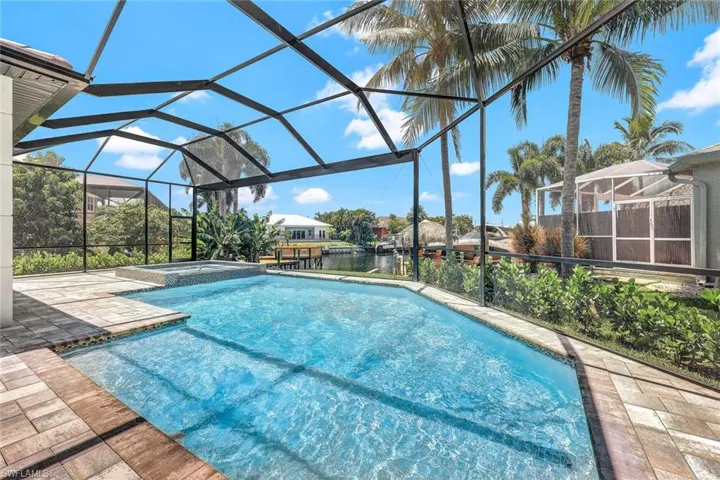 View of pool with a lanai, an in ground hot tub, and a patio area