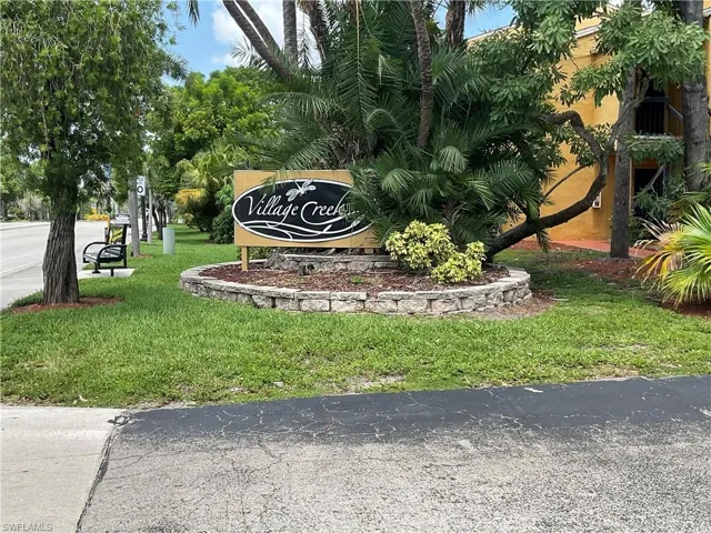 Community / neighborhood sign featuring a yard