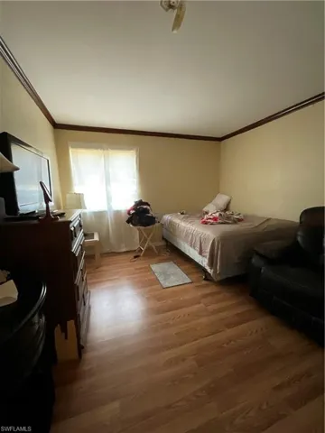 Bedroom featuring wood-type flooring and ornamental molding