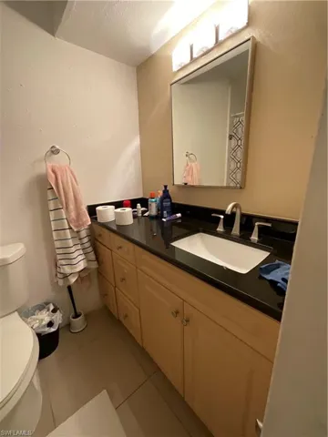 Bathroom with vanity, toilet, and tile patterned floors