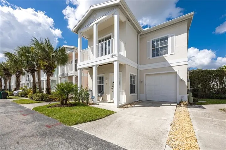 View of front facade featuring a balcony and a garage