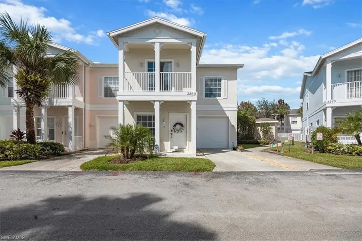 View of front of home featuring a garage and a balcony