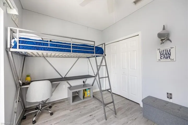 Bedroom with wood-type flooring, a closet, and ceiling fan