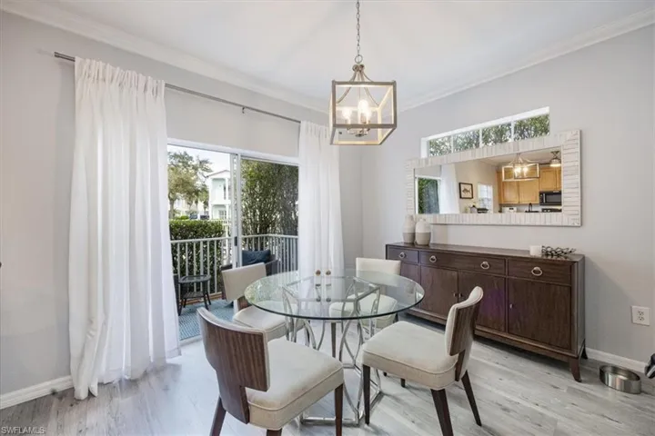 Dining room with light hardwood / wood-style floors, ornamental molding, and a chandelier