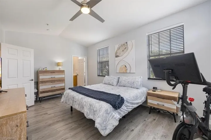 Bedroom featuring light hardwood / wood-style flooring, multiple windows, and vaulted ceiling