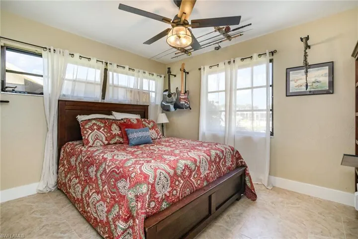 Bedroom with multiple windows, baseboards, and a ceiling fan